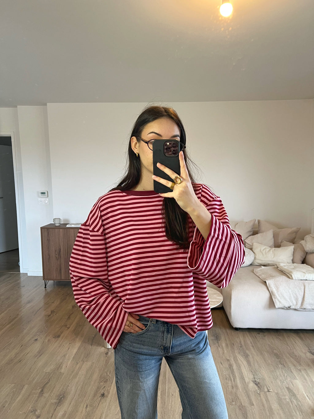 Haut T-shirt Dounia Oversize à rayure bordeaux et rose, manches longues, coupe ample, porté avec jean pour un look casual et moderne.