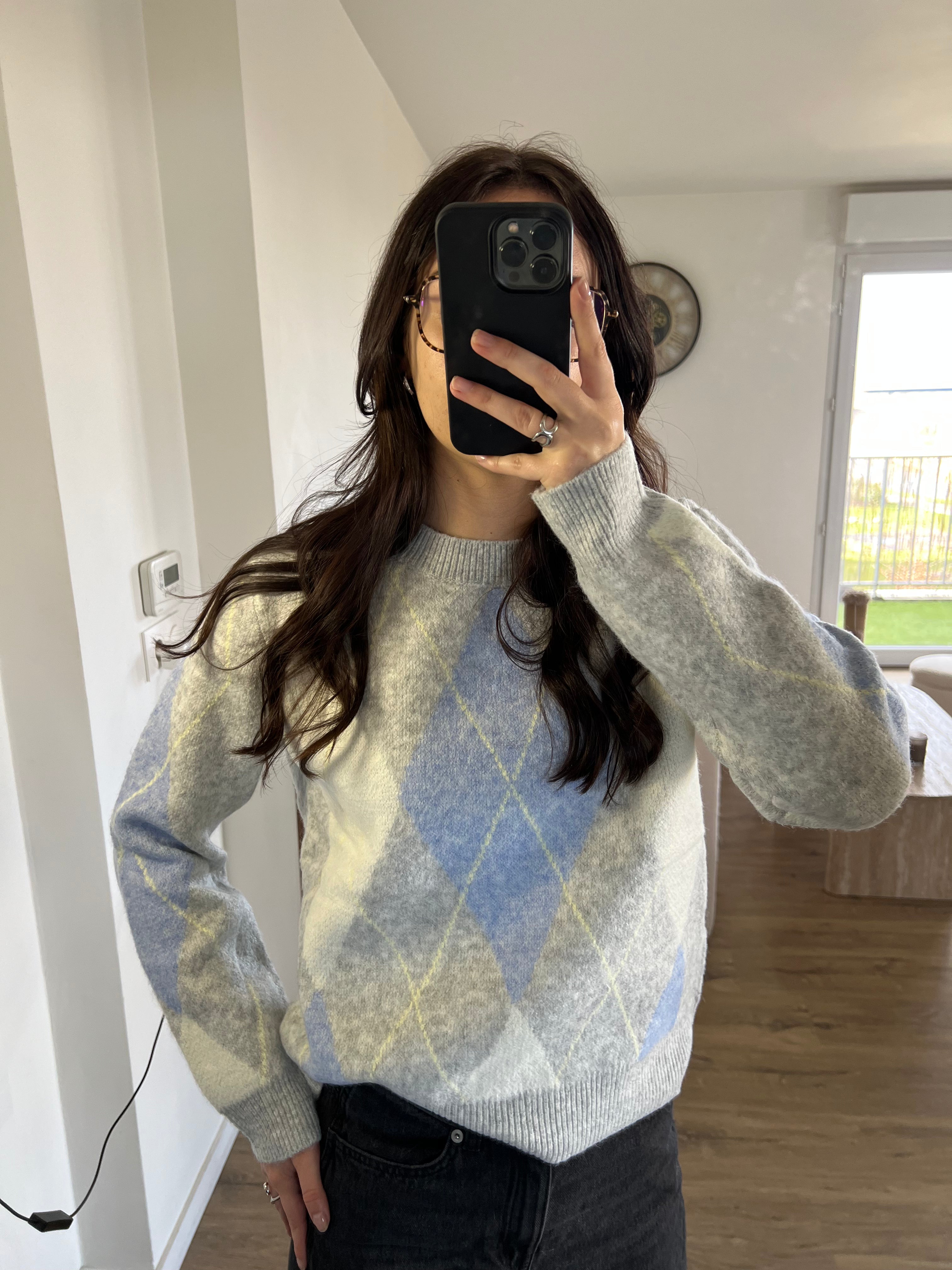 Pull Ema en maille jacquard losange gris et bleu porté avec jean pour un look casual et tendance.