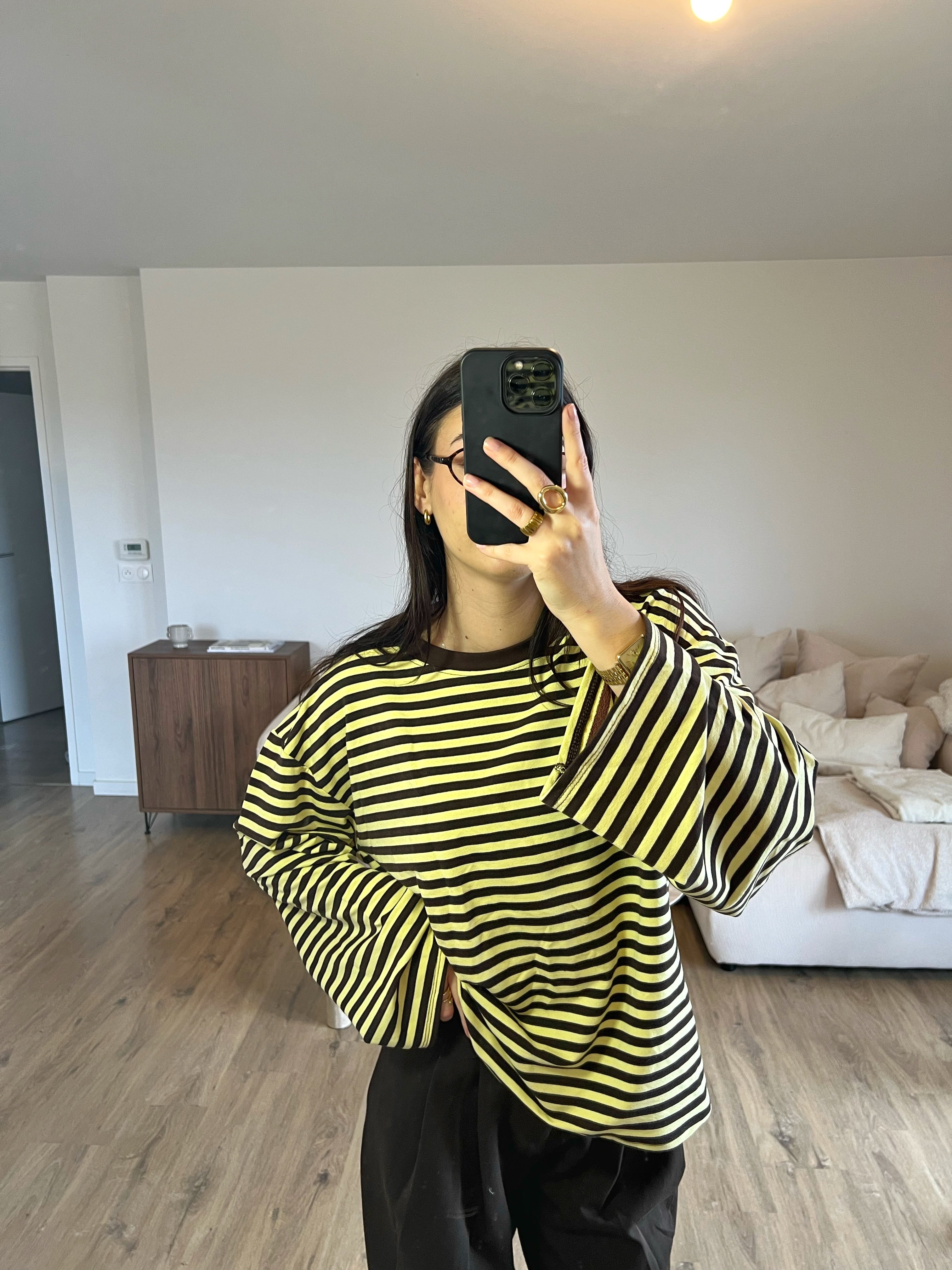 Top Dounia Oversize rayures marron et jaune, coupe ample et manches longues, porté avec pantalon fluide pour un look tendance et facile à associer au printemps.