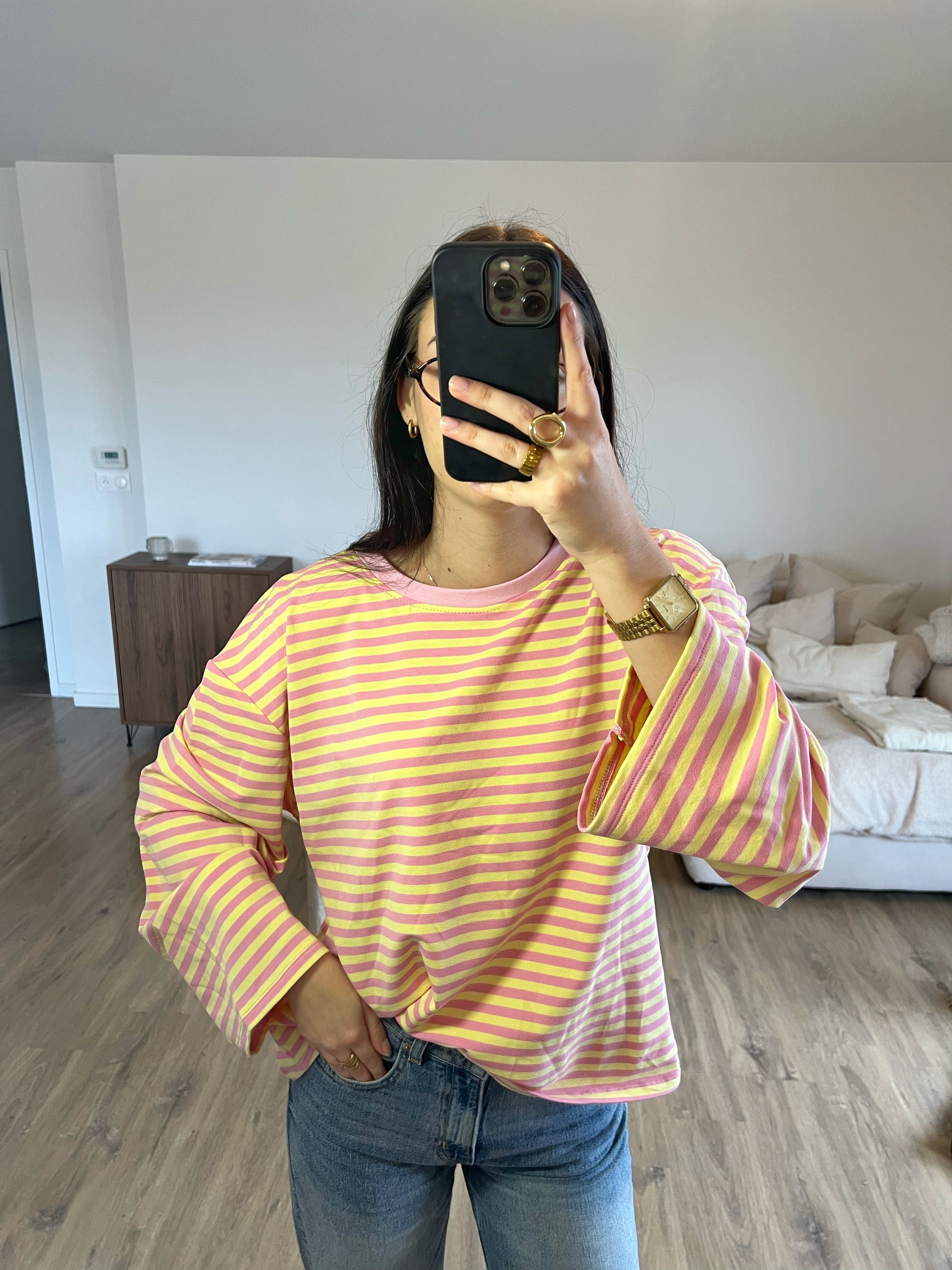 Top Dounia Oversize rayé rose clair et jaune, coupe ample et manches longues, porté avec jean pour un look tendance et facile à associer.